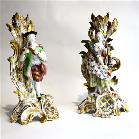 COPPIA CANDELIERI Coppia di porta steli in porcellana policroma "figure...
