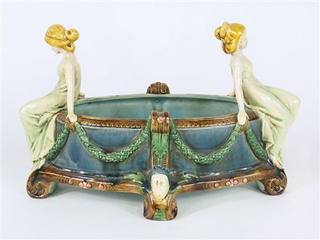 Centrotavola di forma ovale in ceramica policroma con manici a forma di...