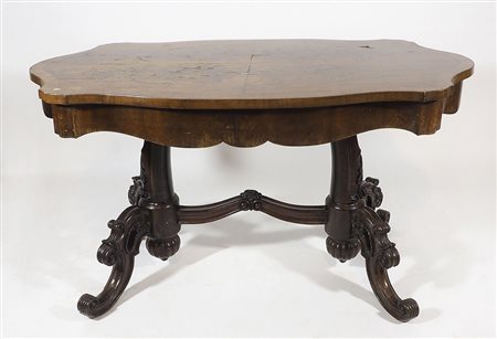 Tavolo rettangolare con piano sagomato su gambe scolpite unite da traversa....