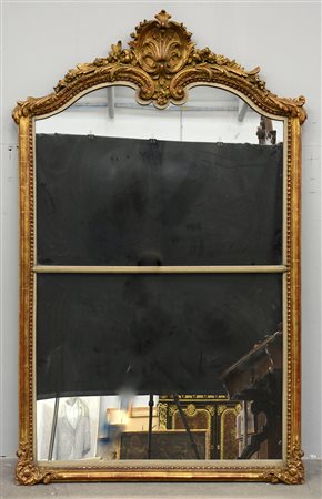 Specchiera in legno e pastiglia dorata con angoli e parte superiore a decoro...