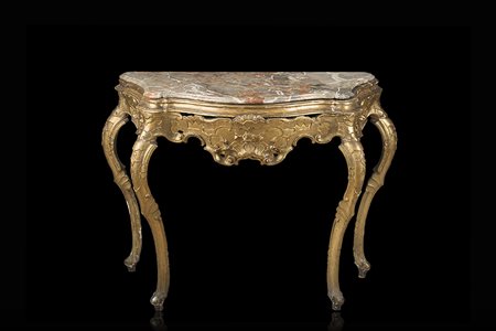 Consolle di forma mossa in legno intagliato e dorato a motivi floreali,...