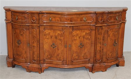Credenza di forma mossa lastronata in noce e radica di noce a tre cassetti e...