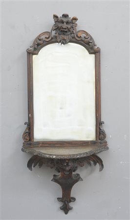 Mensola con specchiera in legno intagliato, decorato con mascheroni, riccioli...