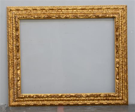 Grande cornice in legno intagliato e dorato con decoro a foglie e frutti in...