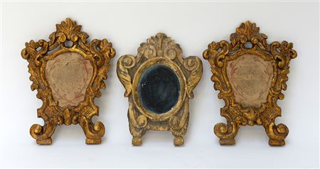 Gruppo di tre cartagloria in legno intagliato e dorato a volute e foglie....