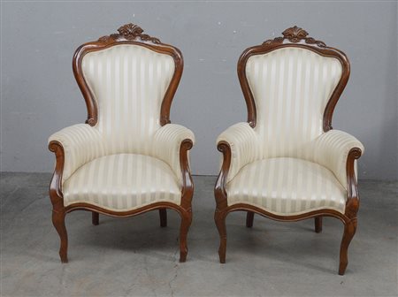 Coppia di poltrone con struttura mossa in noce intagliato con imbottitura...