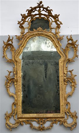 Antica specchiera di gusto rocaille con cornice in legno intagliato e dorato...