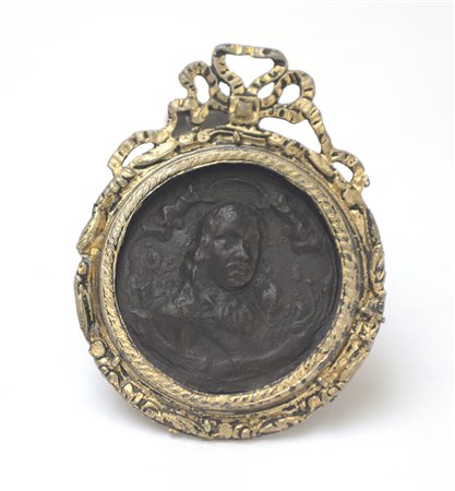 Bassorilievo in bronzo raffigurante un volto sulla parte anteriore e due navi...