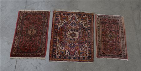 Lotto di tre tappeti orientali con disegno a medaglione su fondo rosso (il...