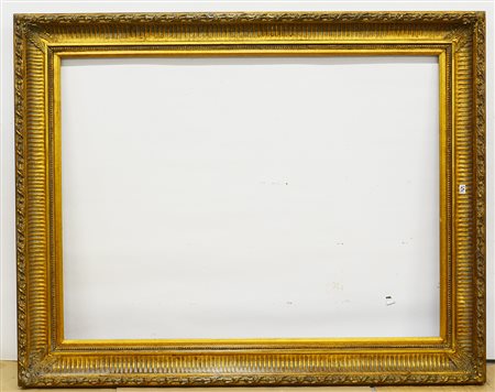 Grande cornice in legno e pastiglia dorata decorata con motivi naturalistici....