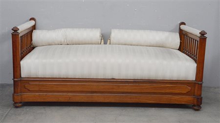 Ottomana in legno con decoro a bugne e fianchi a ringhiera, seduta e cuscini...