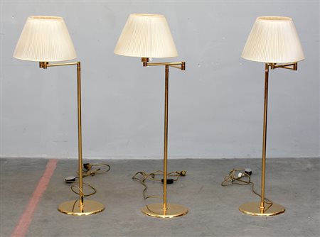 Gruppo di tre lampade da terra in ottone con braccia snodabili ed altezze...
