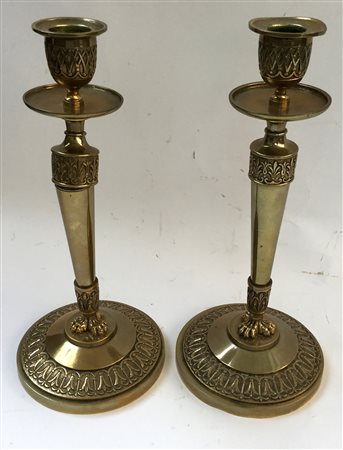 Coppia di candelieri in ottone decorati a motivi concatenati e volute e...