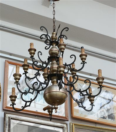 Lampadario in metallo a dodici luci con braccia sagomate a volute (d cm 88)...