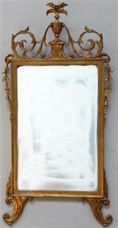 Specchiera con cornice in legno intagliato e dorato a foglie e volute...