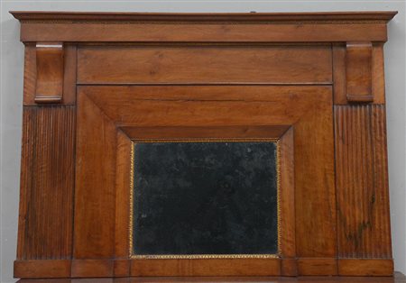 Caminiera in noce con piccolo specchio e fasce laterali scanalate sormontate...