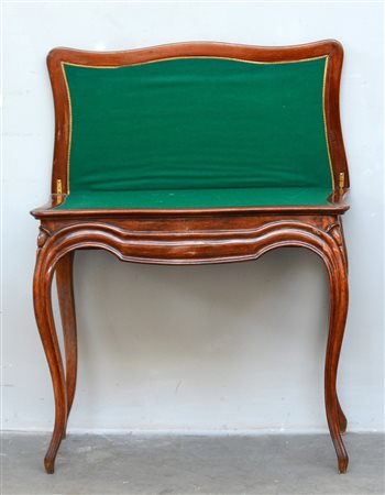 Tavolo da gioco con piano sagomato a libro, lastronato in noce e radica....