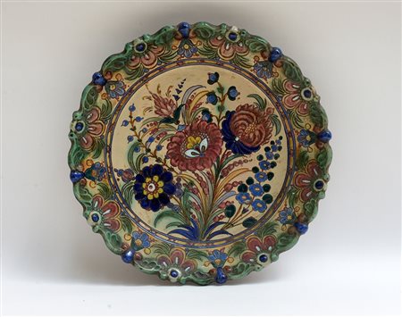 Manifattura italiana, piatto in terracotta smaltata con decoro floreale...
