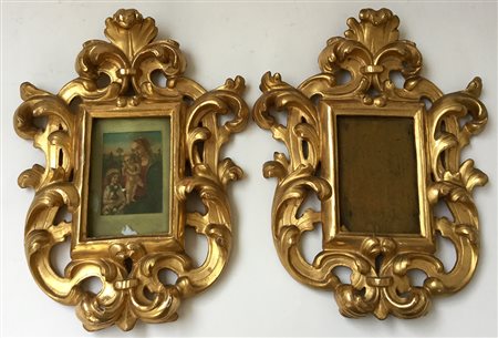 Coppia di cornici in legno intagliato e dorato a volute fogliate (luce cm 14x9)