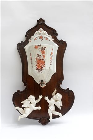 Acquamanile con vasca in ceramica, pannello in legno sagomato e due amorini...