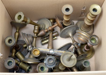 Cartone contenente numerosi candelieri in bronzo e ottone di diversa epoca...
