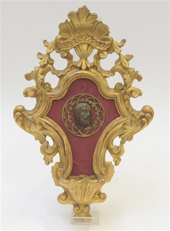 Acquasantiera in legno dorato e intagliato decorato al centro da medaglione...