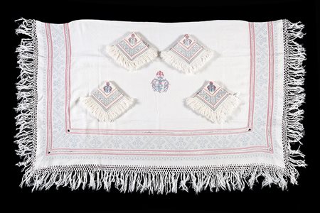 Tovaglia in lino bianco operato, decorata con stemma visconteo in azzurro,...