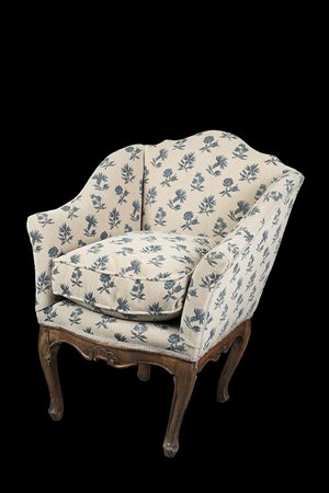 Poltrona a pozzetto in noce con gambe a fasce mosse e intagliate a motivi...