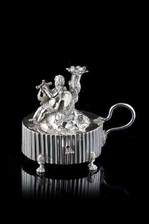 Bugia in argento di forma ovale decorata con angelo musicante su roccia. Roma...