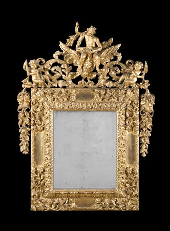 Specchiera in legno con cimasa intagliata con figura di Zeus e amorini. Fregi...