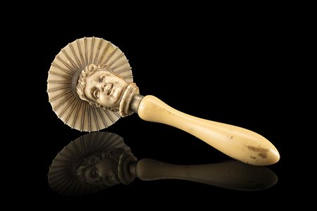 Toy in avorio intagliato con testa di fanciullo con cappello, presa tornita....