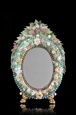 Specchio di forma ovale con cornice decorata in pasta di vetro e vetro a...