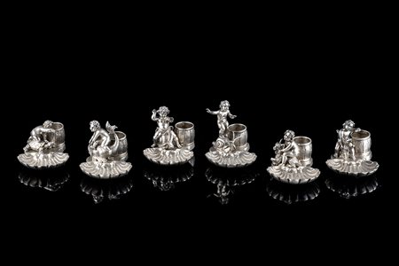 Sei segnaposto in argento raffiguranti putti giocosi su animali, con...