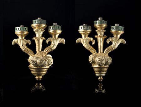 Coppia di appliques a tre luci in legno intagliato e dorato scolpito a volute...