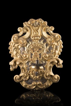 Applique in legno intagliato e dorato a volute e girali di fiori, centrata da...