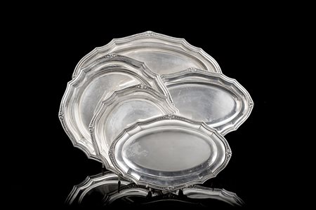 Parte di servizio da tavola in argento con bordi sagomati decorati a volute...