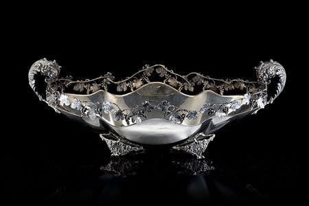 Centrotavola in argento di forma ovale costolata e sagomata, con sponda di...