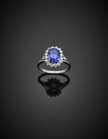 Anello in oro bianco con diamanti a contornare uno zaffiro a cuscino di ct....