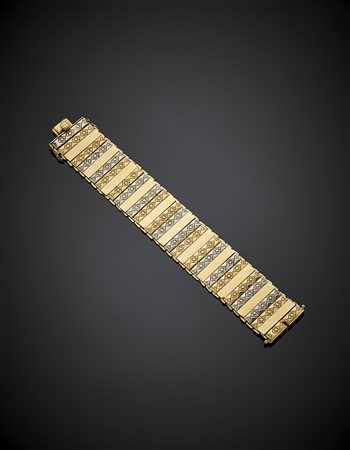 Bracciale a fascia articolata in oro giallo e bianco in parte cesellato, g...