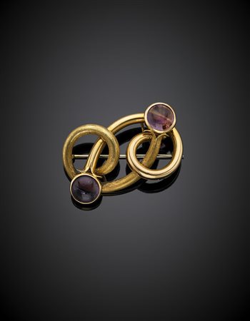 Spilla in oro giallo in parte cesellato, a volute con due ametiste cabochon,...