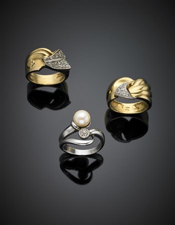 Lotto di tre anelli in oro giallo e bianco rifiniti con diamanti e una perla,...