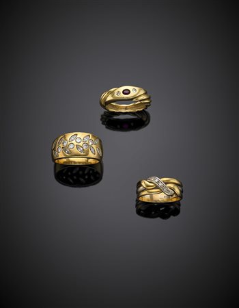 Lotto di tre anelli in oro giallo e bianco rifiniti con diamanti e un rubino,...