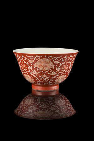 Coppa in porcellana a smalti rosso corallo a decoro floreale in riserva,...