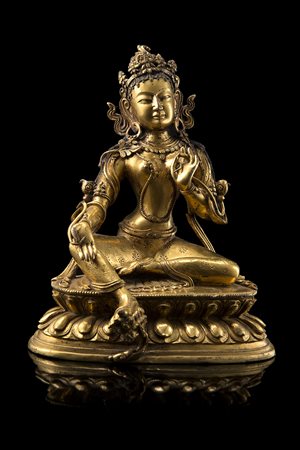 Tara in bronzo dorato, raffigurata seduta su base a doppio loto...
