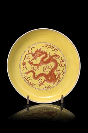 Piatto in porcellana decorato con drago a smalti arancio su fondo giallo,...