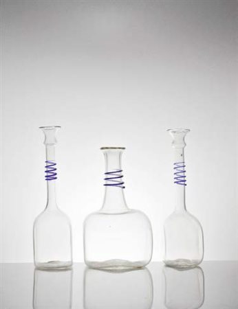VENINI Tre bottiglie in vetro trasparente con collo decorato con applicazioni...