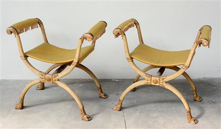 Coppia di faldistorî in legno intagliato, laccato bianco e dorato, com gambe...
