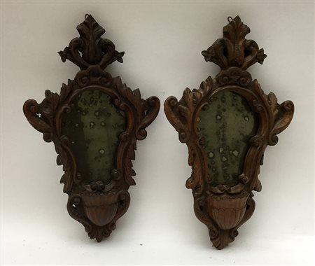 Coppia di acquasantiere sagomate in legno intagliato a motivi vegetali e...