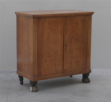 Credenzino in legno dolce a due battenti con piedi anteriori a zampa ferina....