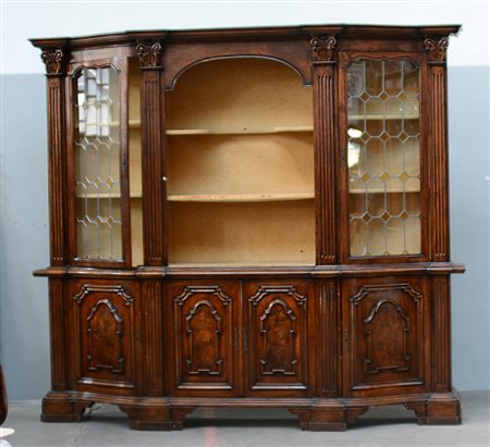 Mobile libreria a due corpi in legno a tinta scura con fronte mossa. Parte...